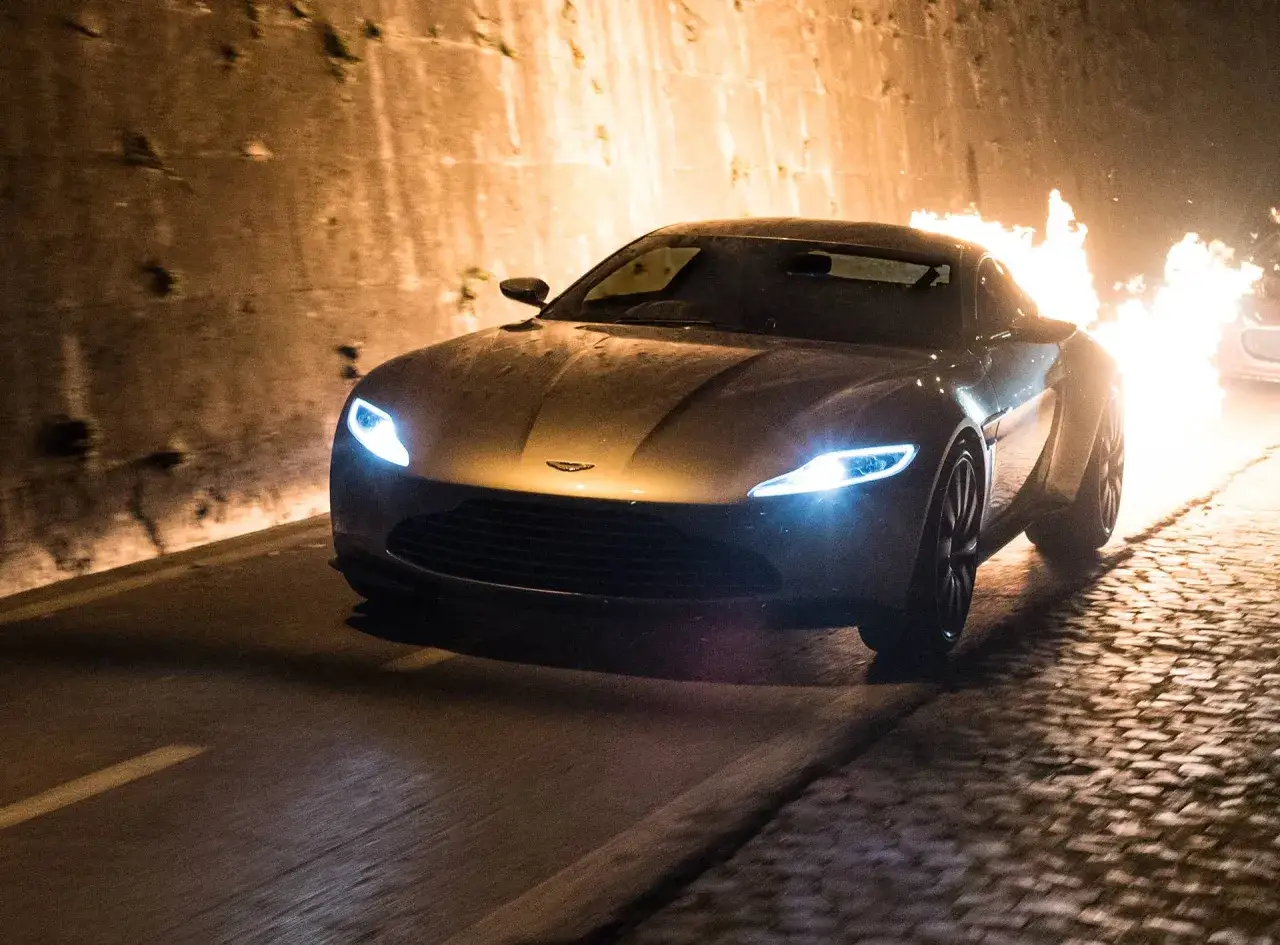 Aston Martin DB10 w płomieniach, pędzący przez tunel.