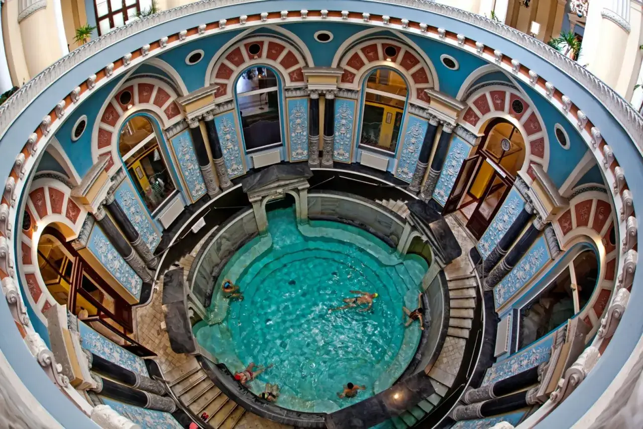Ein prächtiges Thermalbad mit türkisfarbenem Wasser und Menschen, die schwimmen. Ein perfekter Ort für einen erholsamen Polen Urlaub.