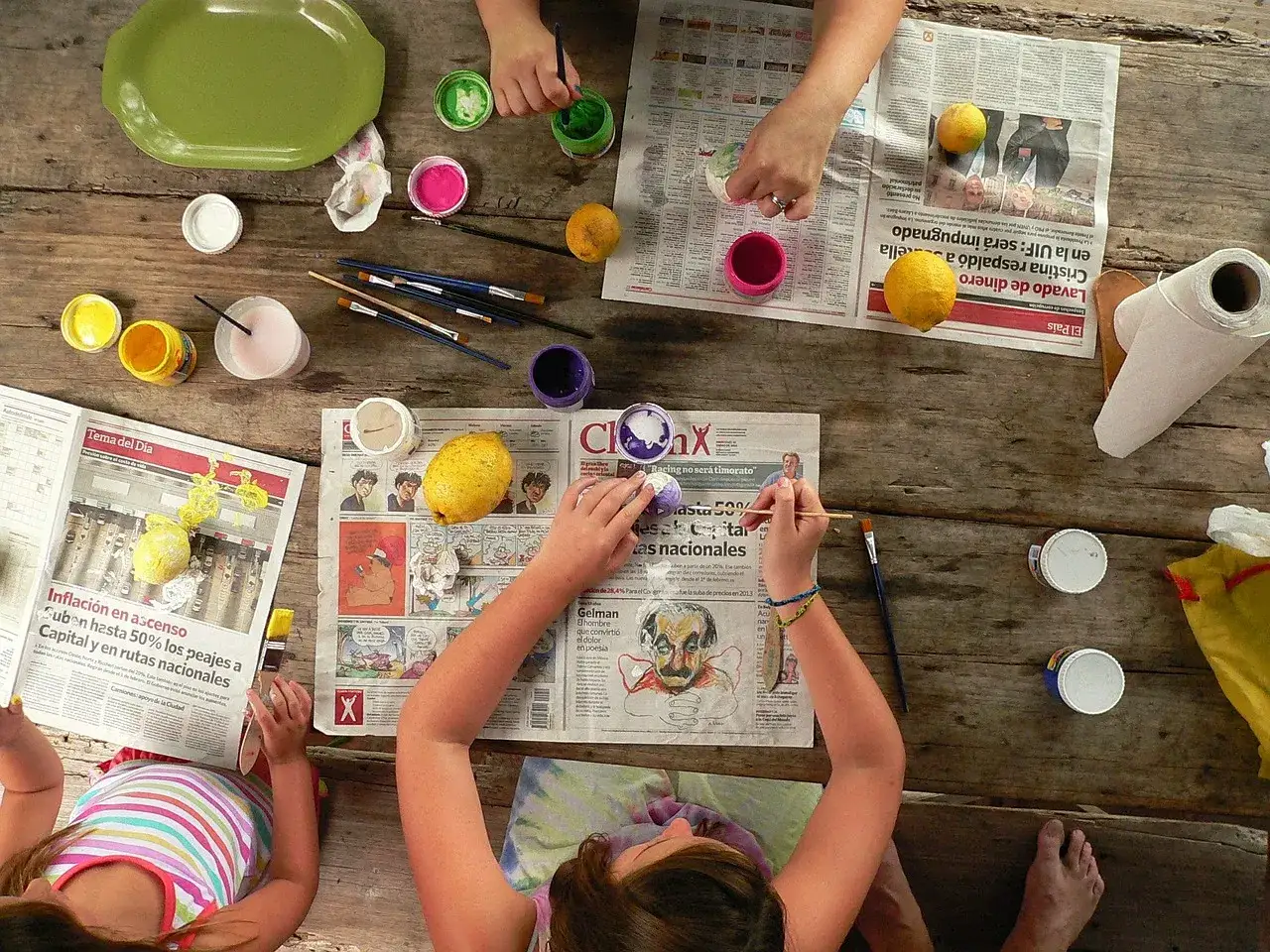 Manos pintando limones y peri&oacute;dicos. Una actividad creativa para ni&ntilde;os, como si fueran deportes para ni&ntilde;os.