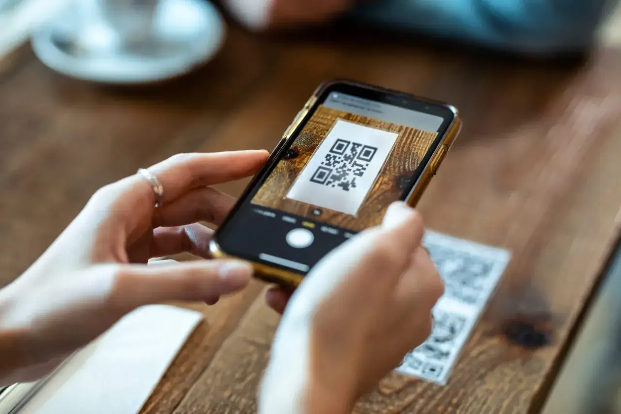 En person h&aring;ller upp en mobiltelefon f&ouml;r att skanna en QR-kod, liknande hur ett digitalt simkort kan anv&auml;ndas f&ouml;r att ansluta till n&auml;tverk.