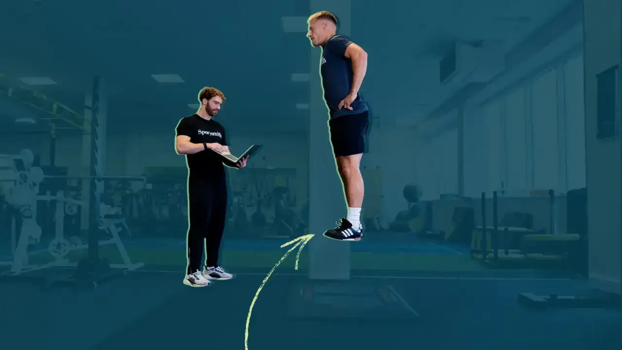 Allenamento forza esplosiva: un atleta salta mentre un allenatore osserva i dati su un laptop.