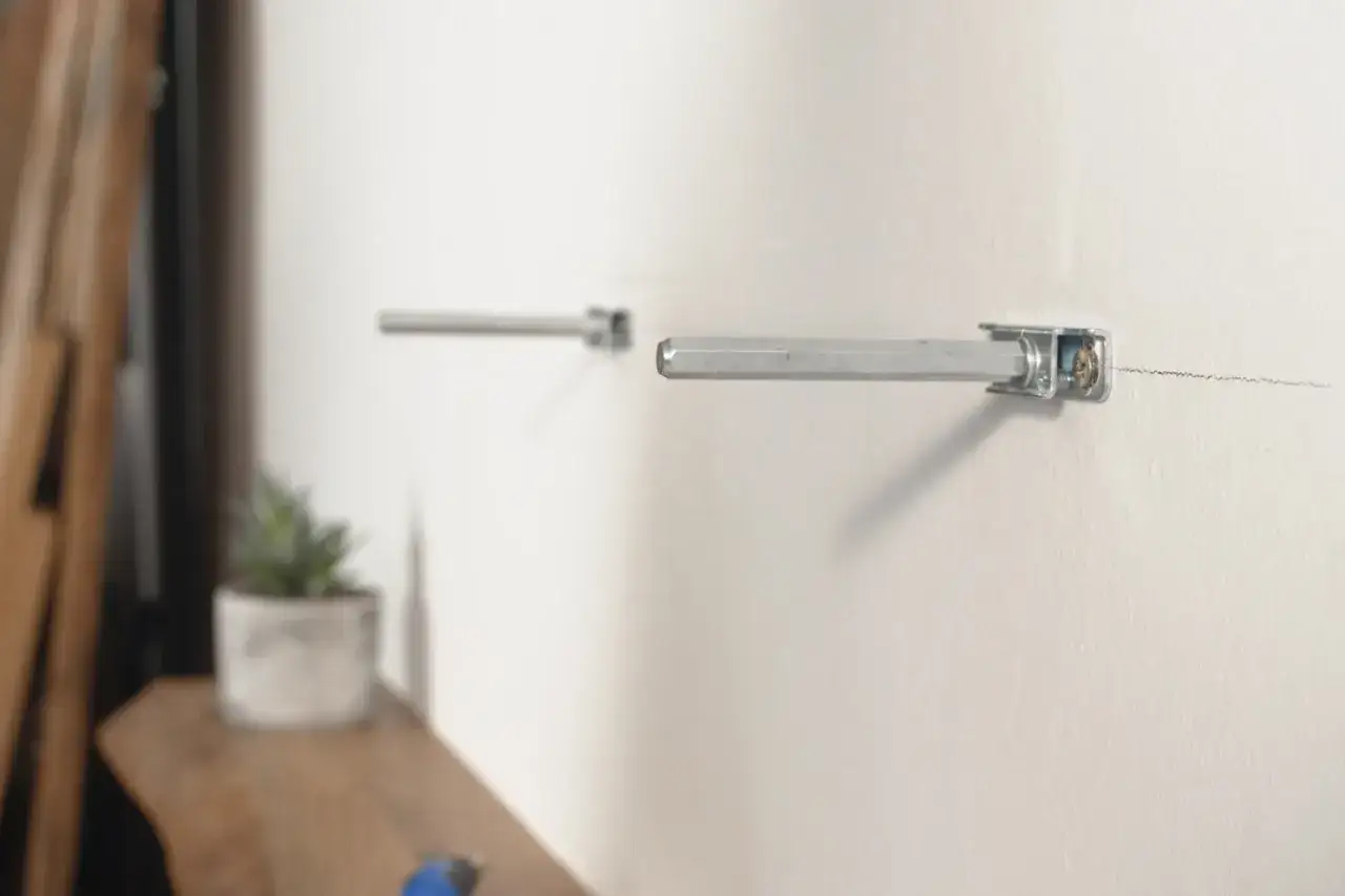 So befestigt man ein Regal: Metallhalterungen werden an der Wand montiert, bereit f&uuml;r das Regal.