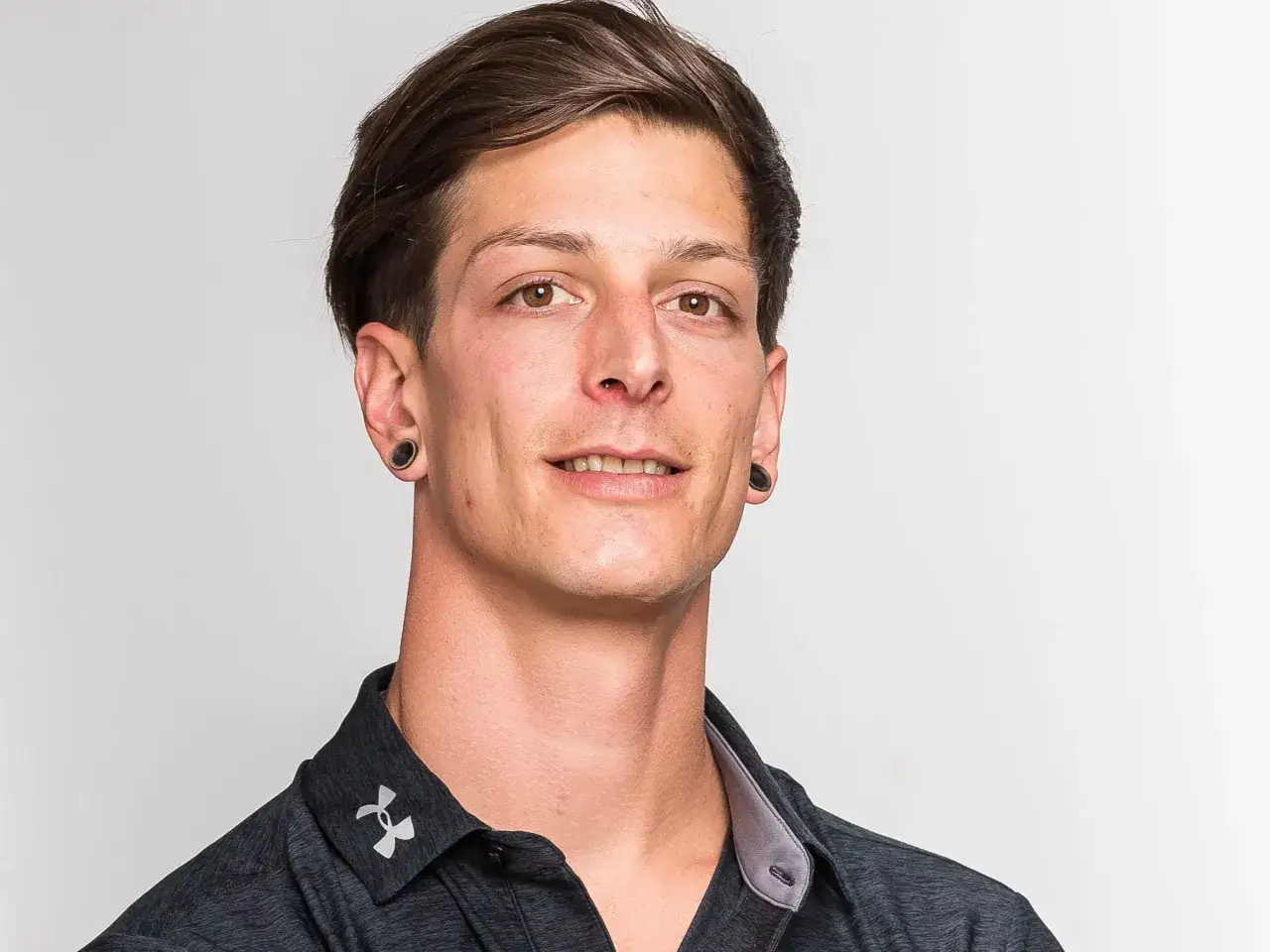 Portret mężczyzny z ciemnymi włosami, w czarnej koszulce. Thomas Thurnbichler wiek nie jest widoczny, ale jego twarz jest młoda.