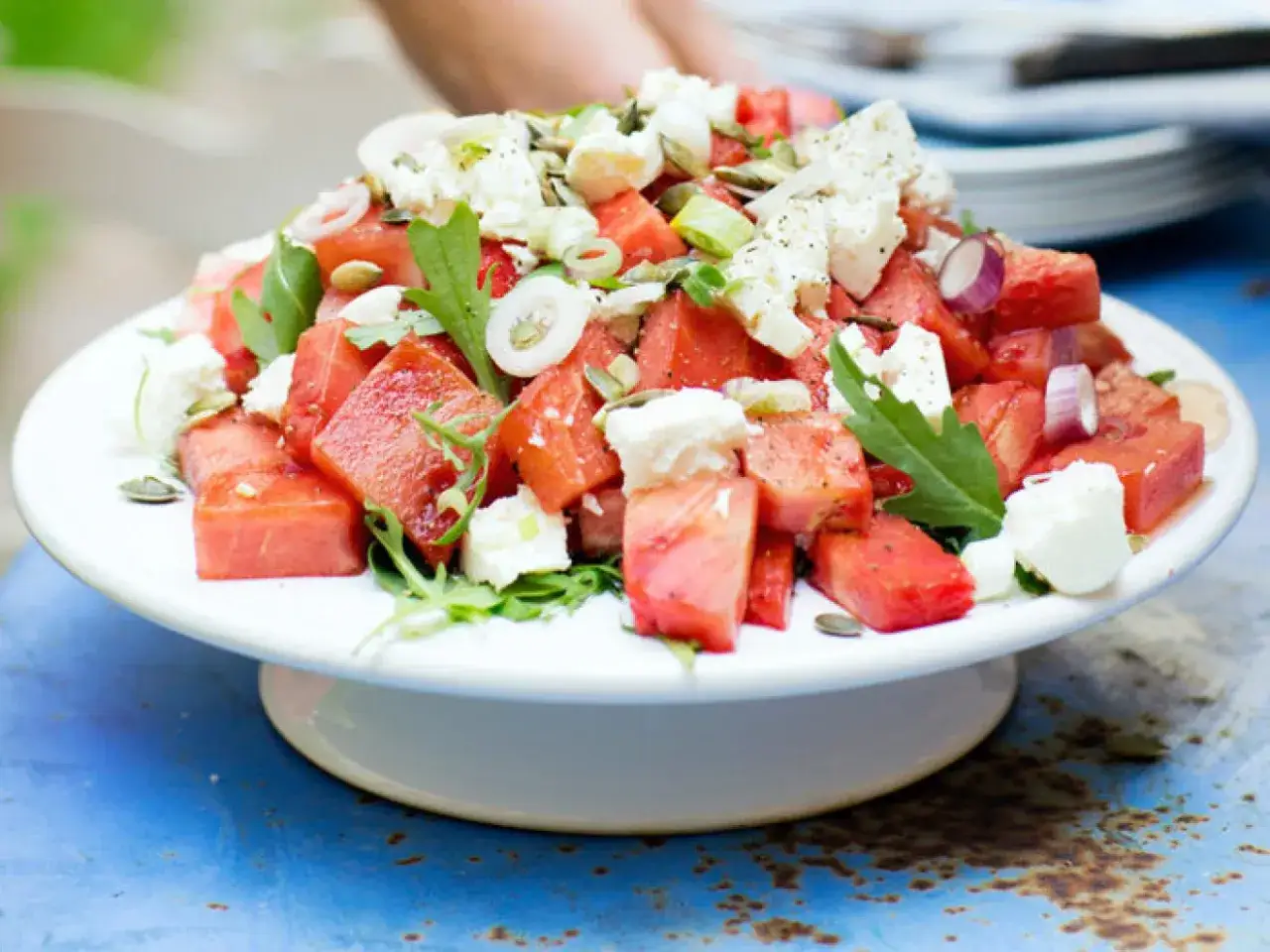 En uppfriskande vattenmelon sallad med fetaost, rödlök och pumpafrön. Perfekt för en varm sommardag.