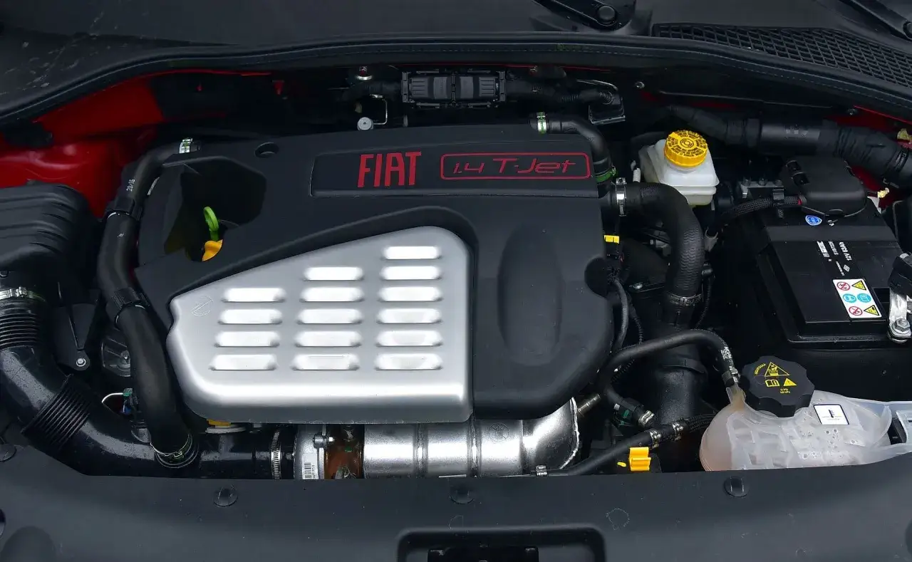 Silnik Fiat Tipo 1.4 T-Jet. Widoczny blok silnika, turbosprężarka, akumulator i płyny eksploatacyjne.