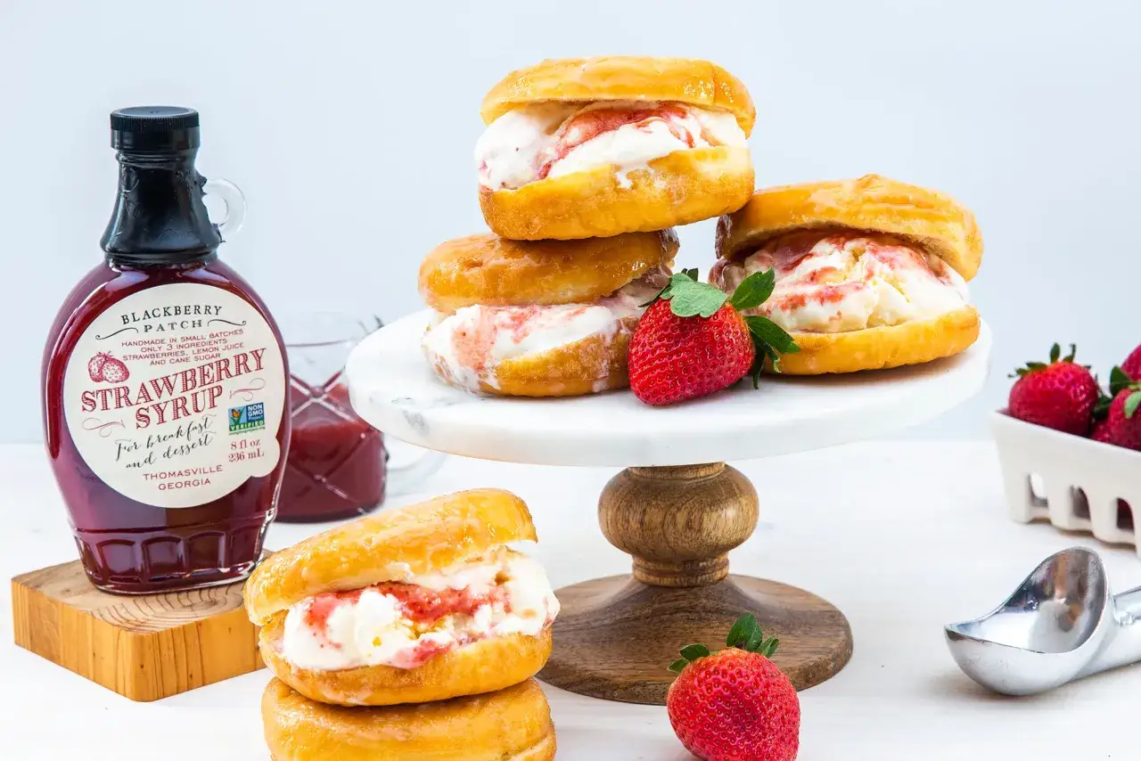 Leckeres Donut-Eis mit Erdbeersirup und frischen Erdbeeren. Ein süßer Genuss!