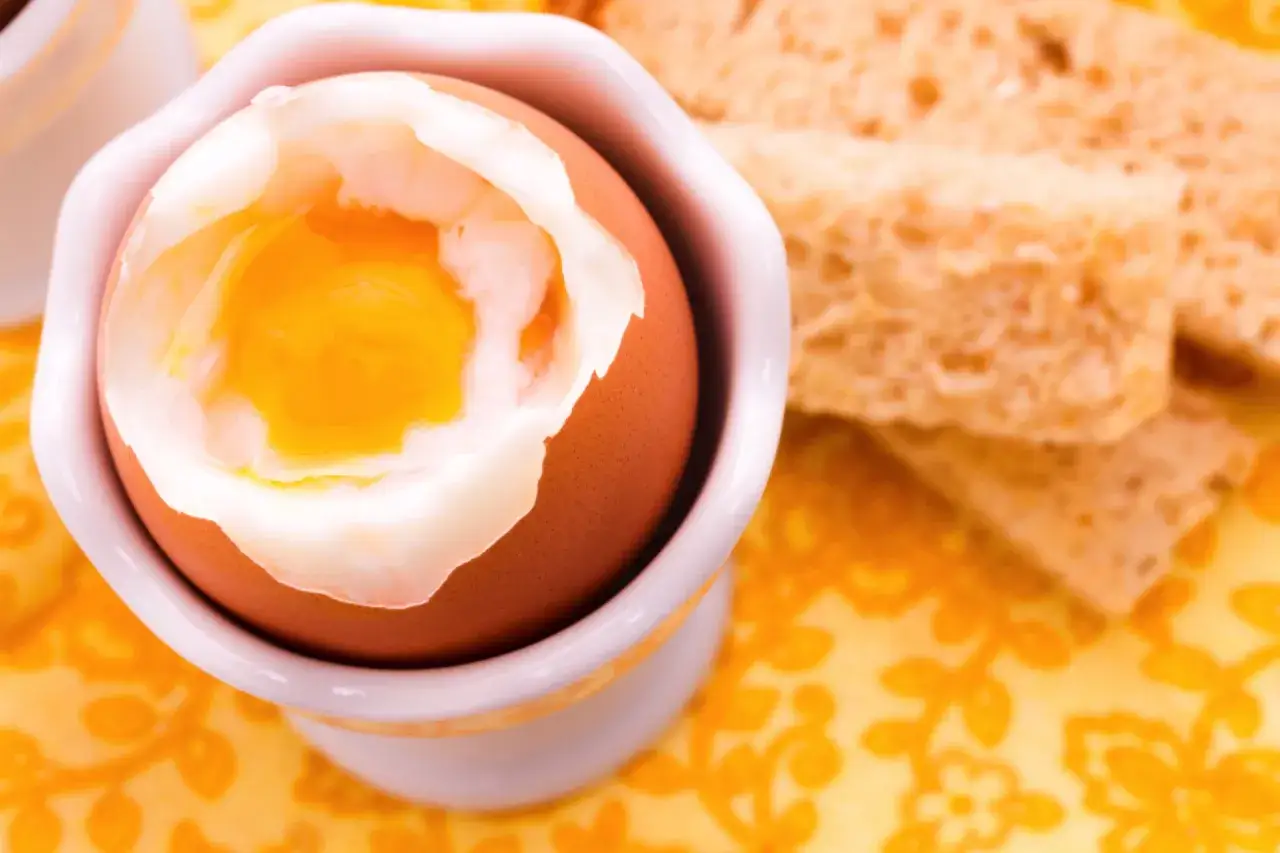 Idealne jajka z airfryer z płynnym żółtkiem, podane z grzankami. Pyszne śniadanie.