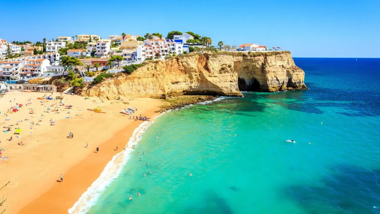 Piękna portugalia wrzesień pogoda. Słoneczny dzień na plaży z turkusową wodą i klifami.