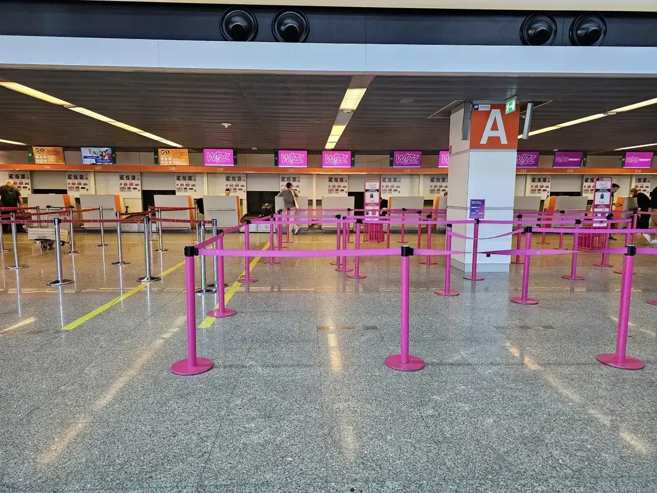 Puste stanowiska Wizzair, gotowe do odprawy. Różowe taśmy wyznaczają kolejki.