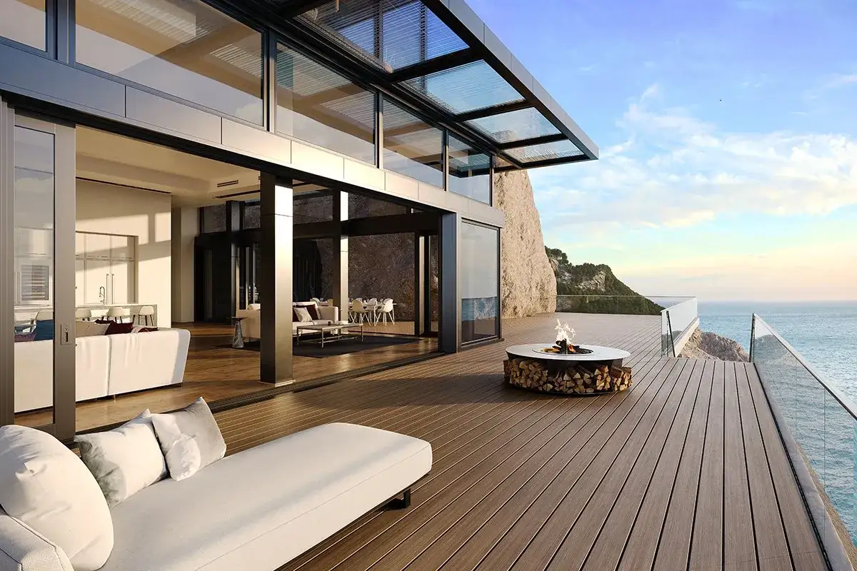 Une luxueuse terrasse en L avec un feu de camp, offrant une vue imprenable sur la mer et un acc&egrave;s &agrave; un salon moderne.