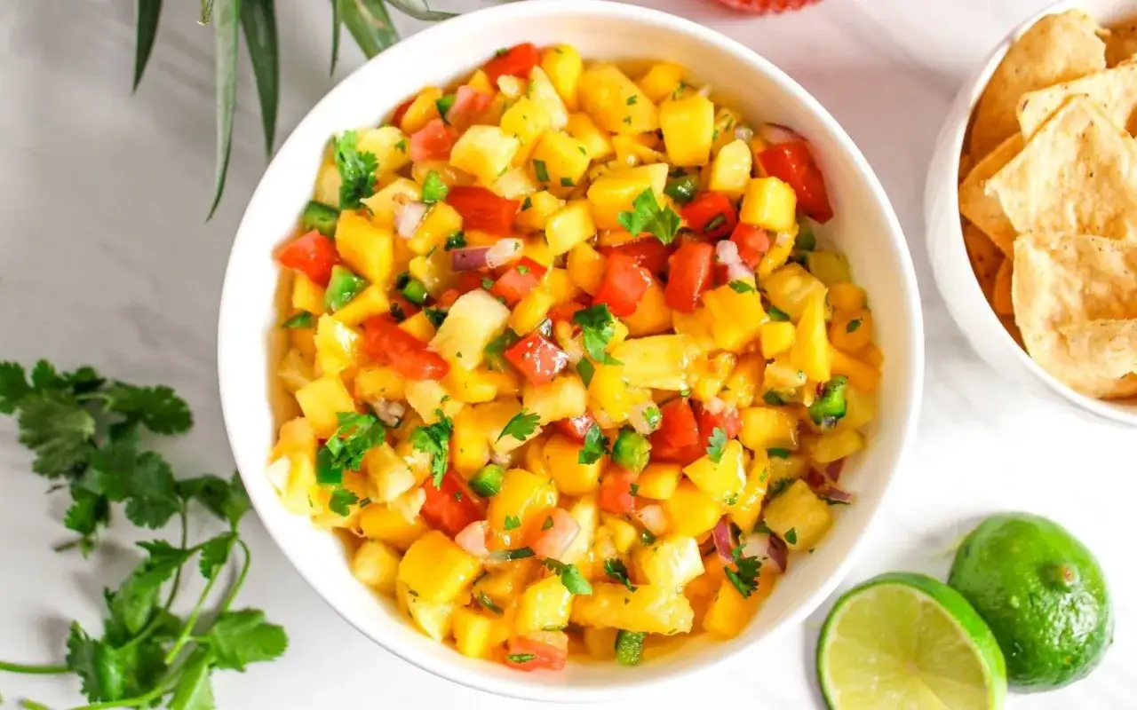 En skål med färgglad mango salsa, full av tärnad mango, tomat, jalapeño och koriander. Perfekt till tortillachips.