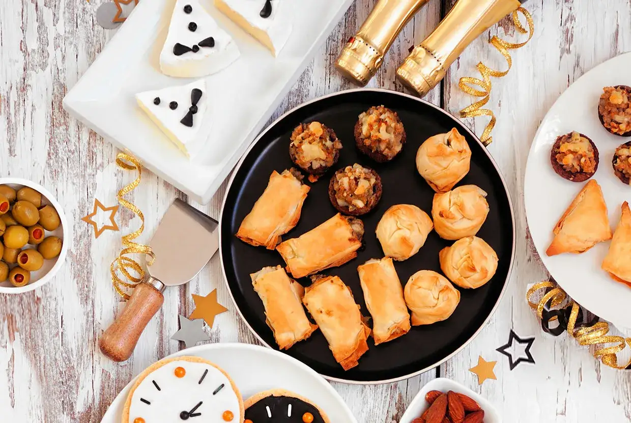 Festliches veganes Fingerfood: Blätterteigröllchen, gefüllte Pilze, Oliven und Kekse. Perfekt für Silvester!