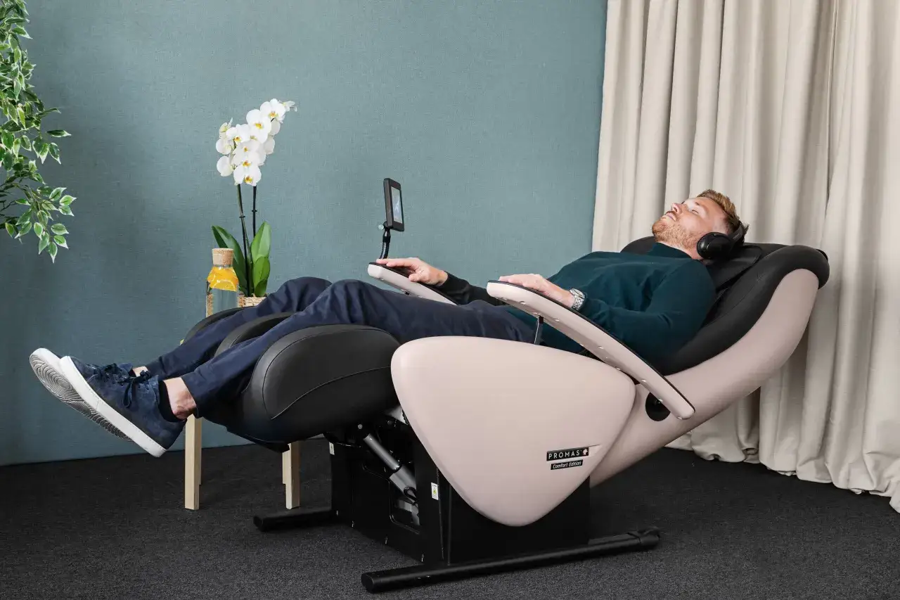 Man kopplar av i en massagestol med h&ouml;rlurar, kanske f&ouml;r att samla kraft inf&ouml;r att byta jobb efter utmattning.