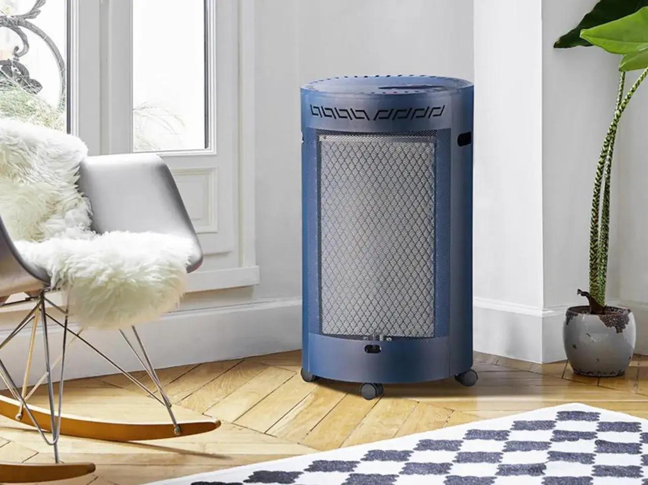 Chauffage d'appoint gaz, un danger potentiel. Appareil bleu sur roulettes, pr&egrave;s d'un fauteuil confortable et d'une plante verte.