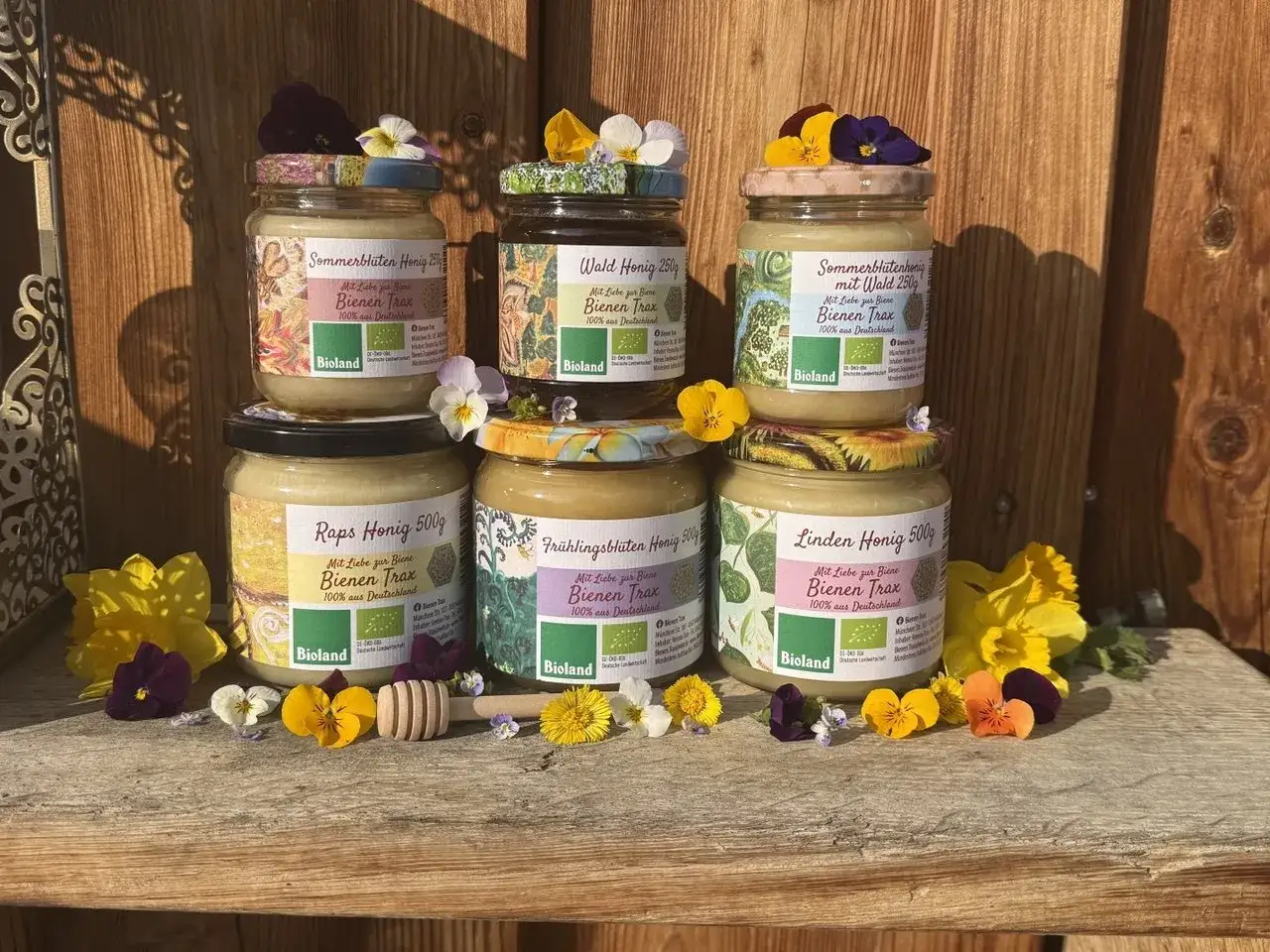 Sechs Gläser mit verschiedenen Honig Sorten: Sommerblüten, Wald, Raps, Frühlingsblüten und Lindenhonig. Bienenfreundlich und 100% aus Deutschland.