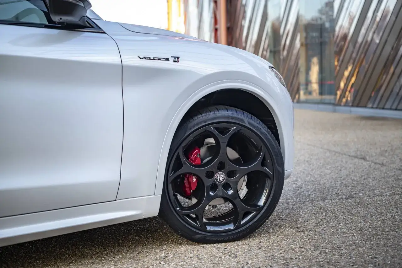 Dettaglio di un'auto bianca con cerchi Stelvio 21 originali e pinze freno rosse.