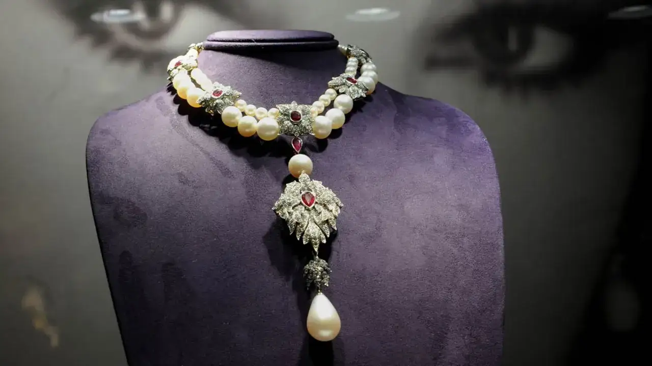Collar de perlas y diamantes con un colgante central, evocando la magnificencia de una perla peregrina.