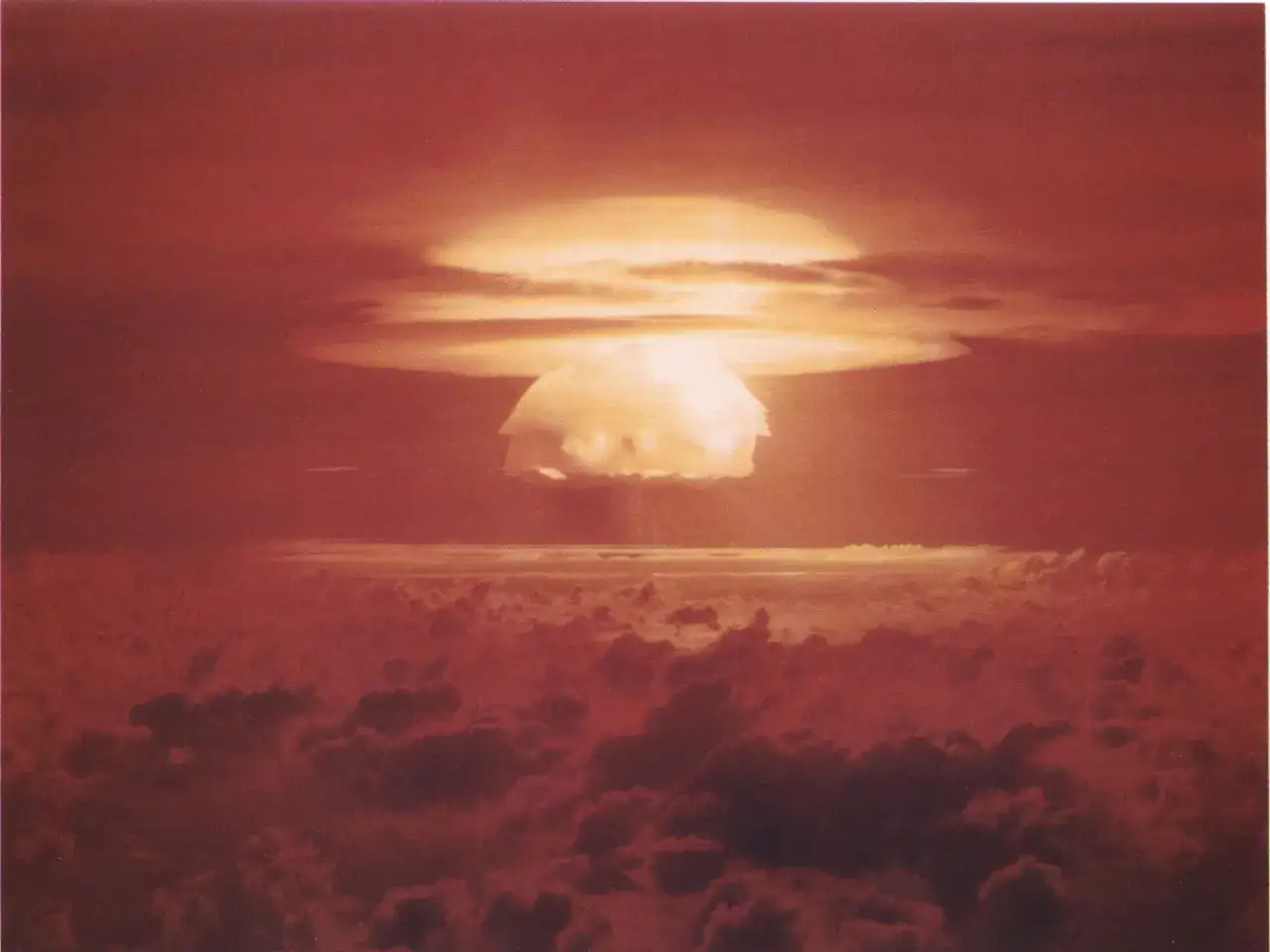 Grzyb atomowy nad chmurami, przypominający kształtem kapelusz. Gdzie jest bikini? To nie plaża, to test atomowy na Bikini Atoll.