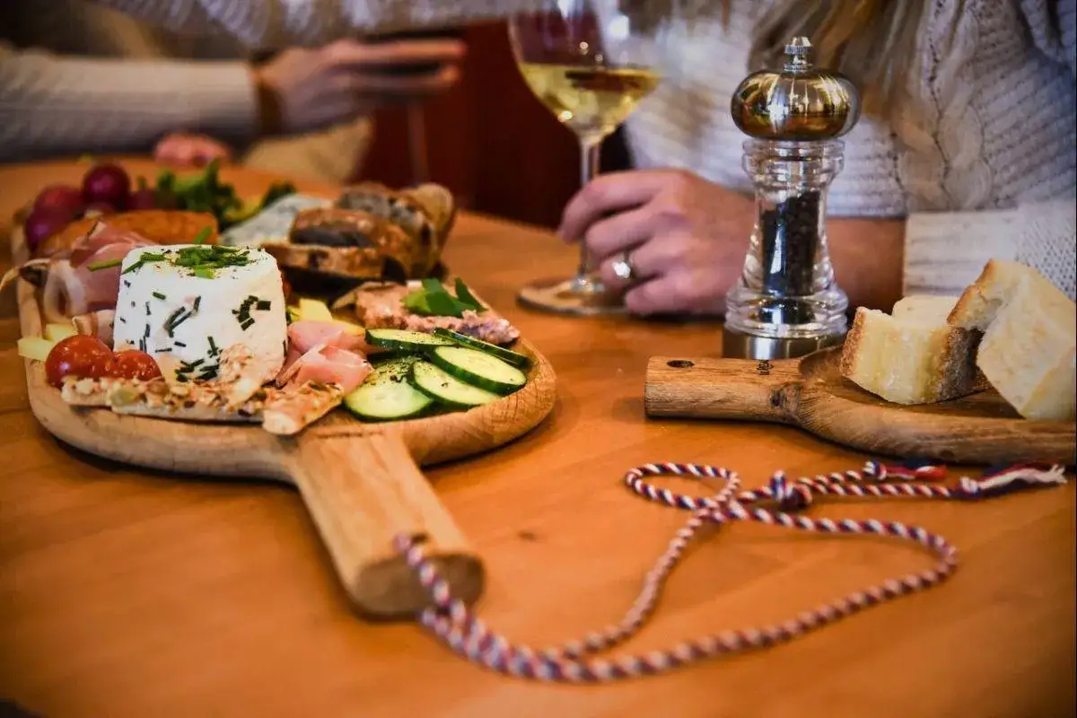 Plateau ap&eacute;ritif avec fromage, charcuterie, pain et l&eacute;gumes. Id&eacute;al pour savoir quoi apporter pour une invitation &agrave; un ap&eacute;ro.