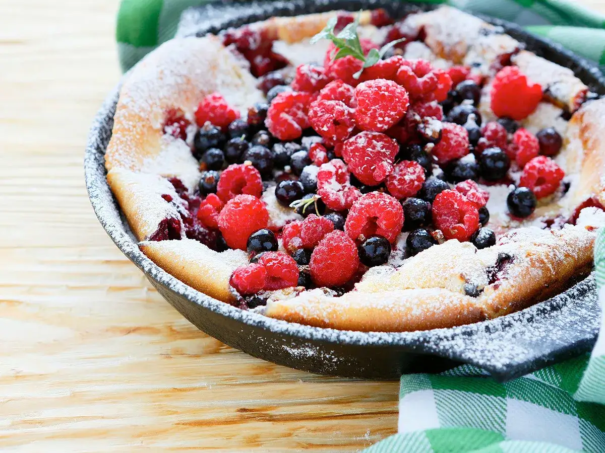 Un clafoutis aux fruits rouges, saupoudr&eacute; de sucre glace, parfait pour une recette clafoutis facile et gourmande.