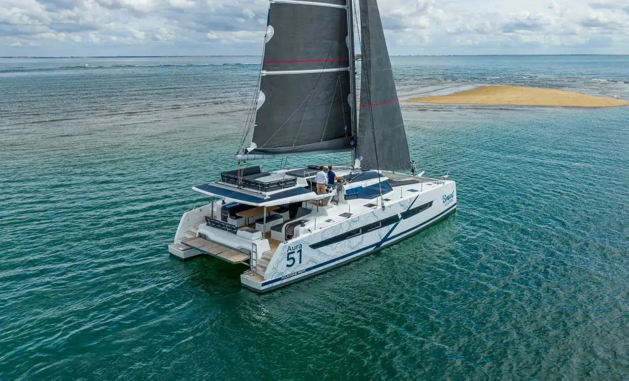 Catamaran Fountaine Pajot Aura 51, modèle modx 70, naviguant sur une mer calme avec deux personnes à bord.