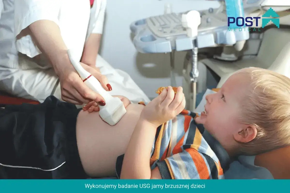 Lekarz wykonuje usg brzuszka niemowlaka. Dziecko leży spokojnie, trzymając w rączce zabawkę.