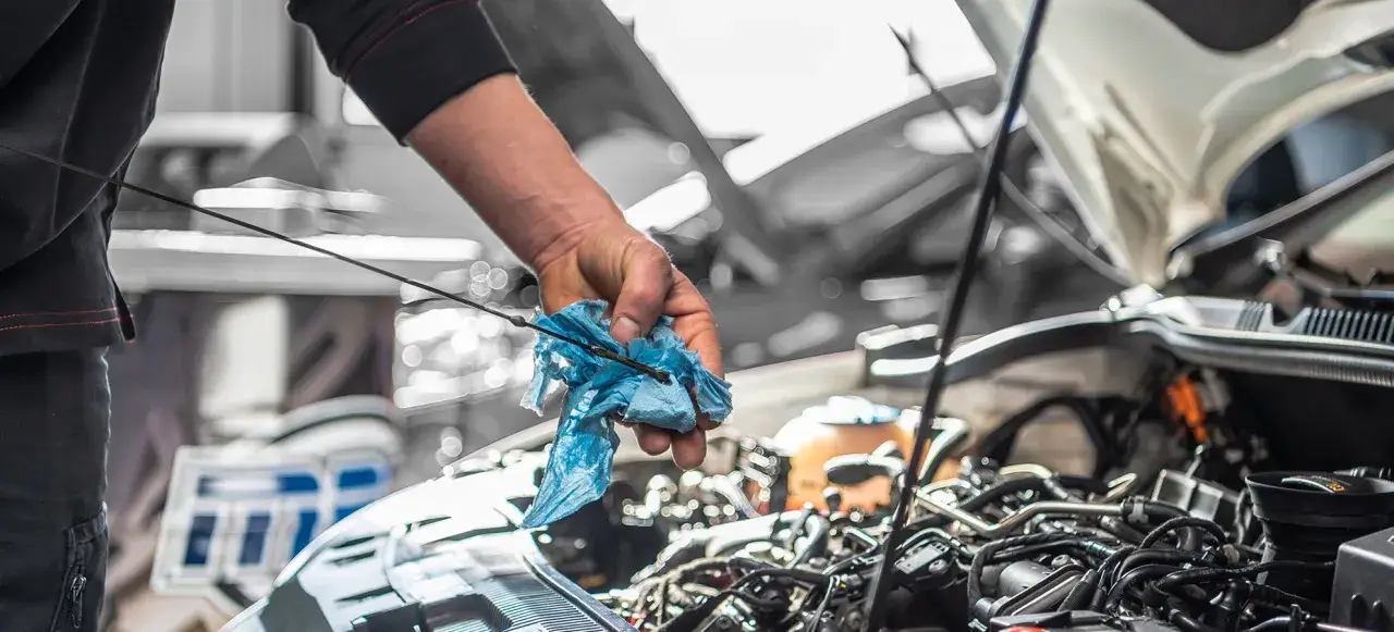 Meccanico controlla l'olio motore, forse per capire perch&eacute; la macchina consuma troppo gasolio.