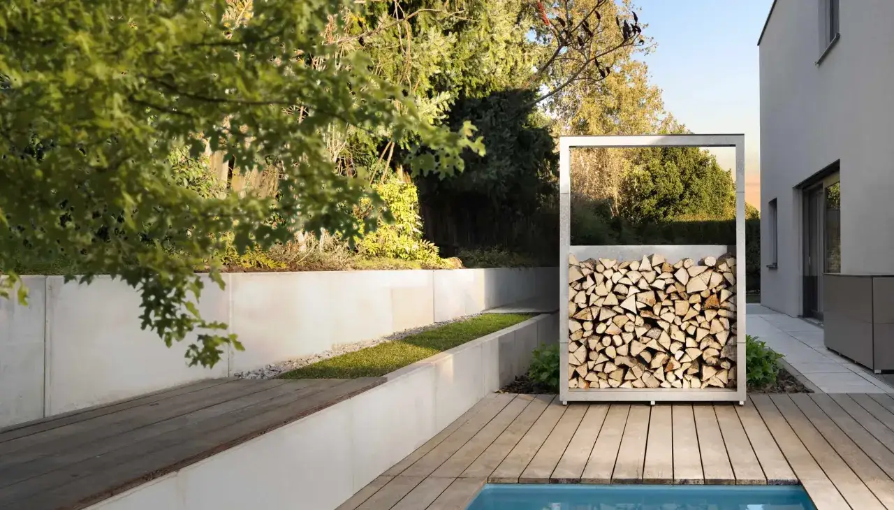 Moderne Holzunterstand Ideen: Ein schlichter Metallrahmen h&auml;lt aufgestapeltes Brennholz neben einem Pool.