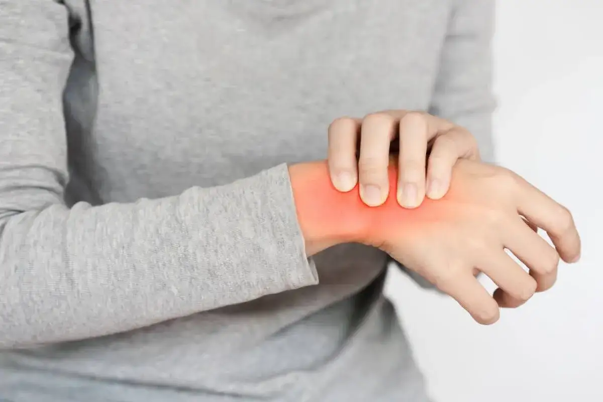 Schmerzende Hand, die sich anfühlt, als ob die Arme nachts einschlafen. Rote Stelle am Handgelenk.