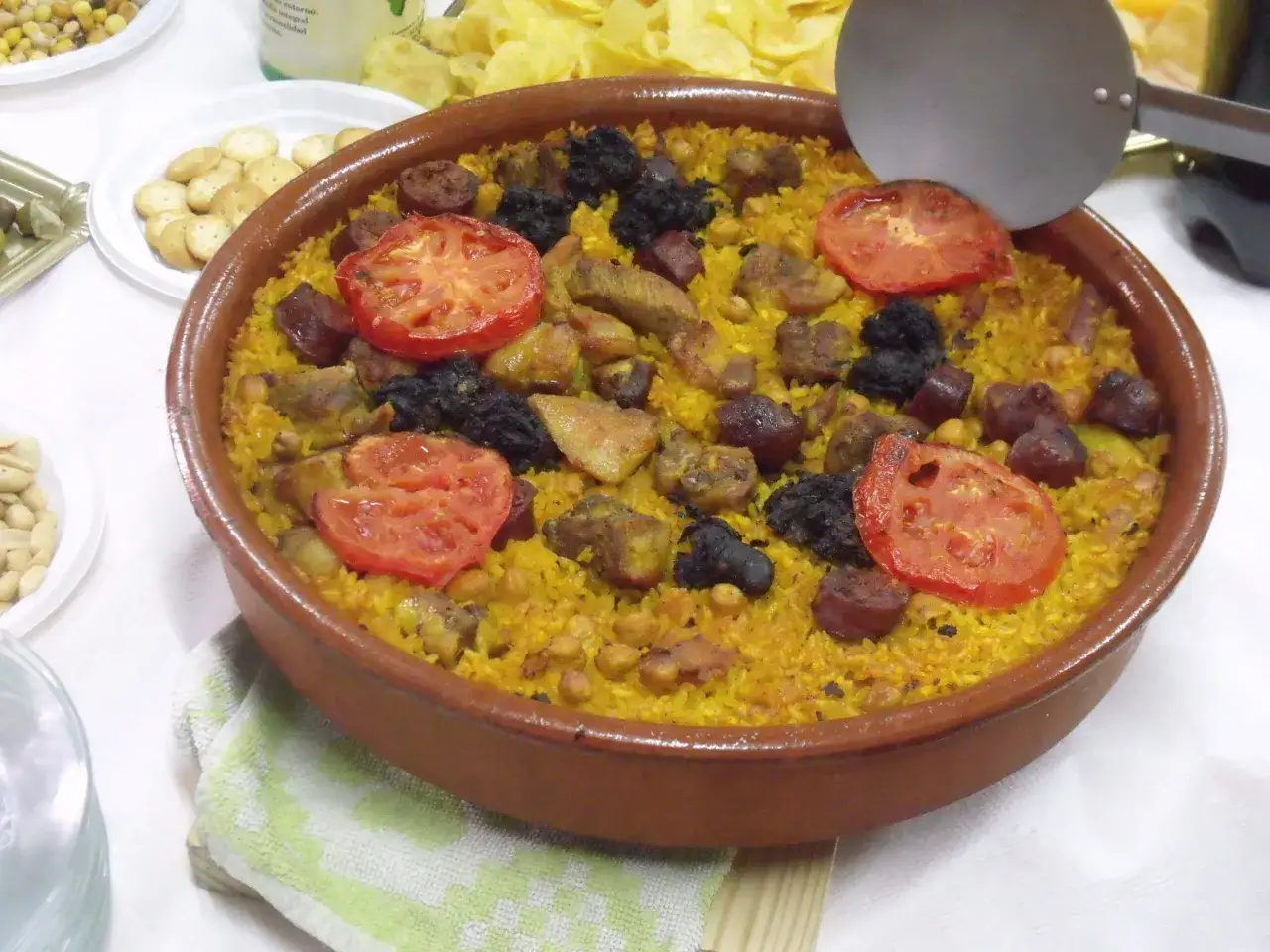 Un delicioso arroz con carne, adornado con rodajas de tomate y chorizo, listo para servir.