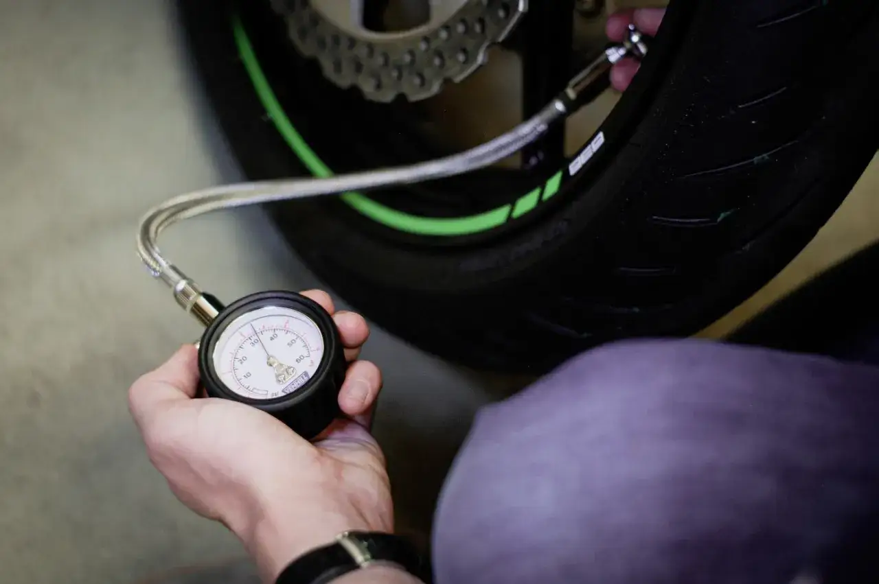 Comprobando la presi&oacute;n de aire de una moto 125. El man&oacute;metro indica la cantidad de aire en el neum&aacute;tico.