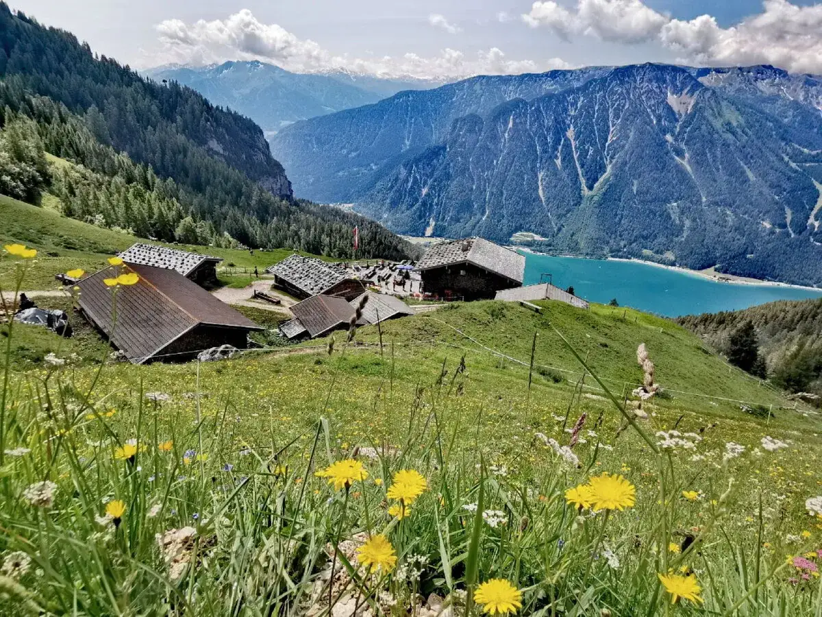 Alpenpanorama mit Bergd&ouml;rfern und t&uuml;rkisfarbenem See. Die Achensee Umrundung bietet diese Aussicht.