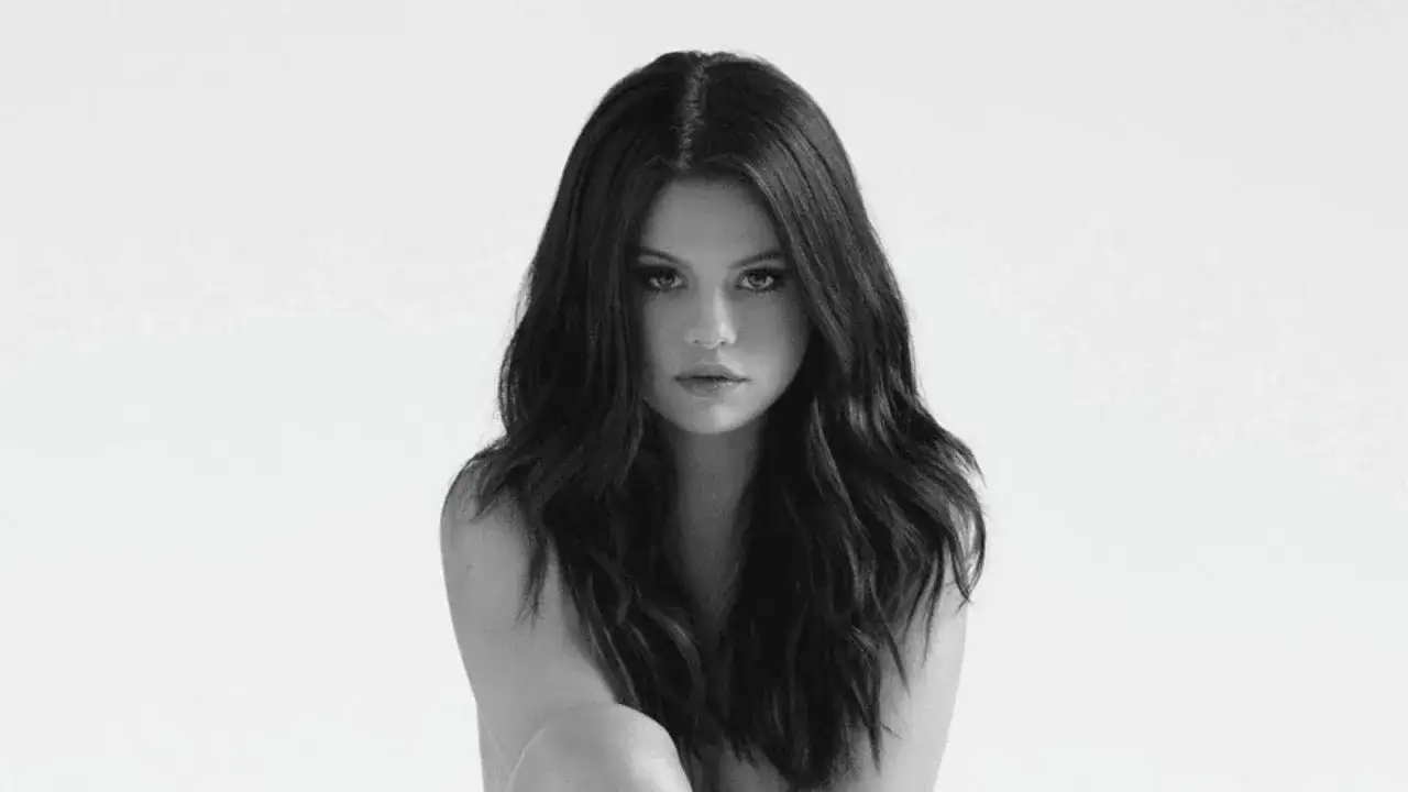 Selena Gomez z długimi, ciemnymi włosami patrzy prosto w obiektyw.