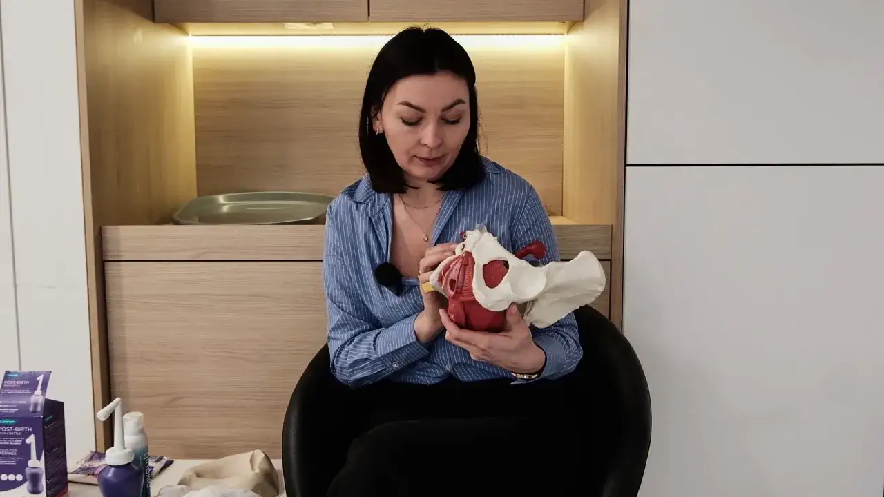 Kobieta omawia model miednicy, kluczowy element w zrozumieniu połogu i regeneracji po porodzie.