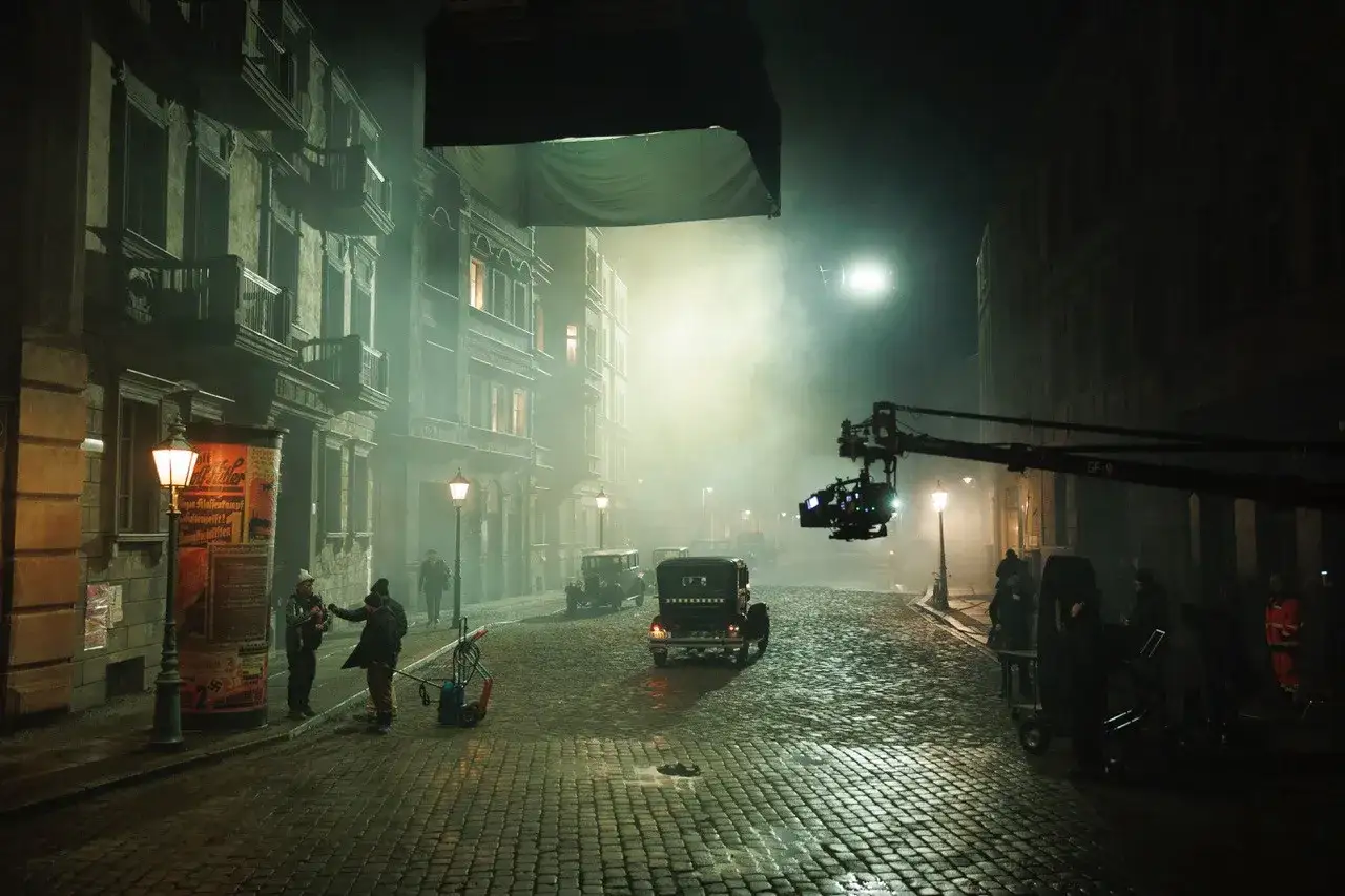 Dreharbeiten f&uuml;r Babylon Berlin Staffel 5: Eine neblige Stra&szlig;e mit alten Autos und einer Filmkamera im Einsatz.