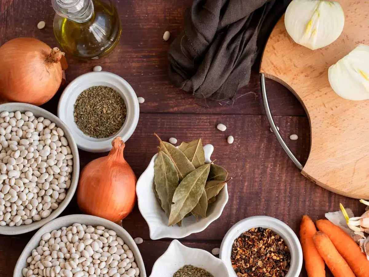 Ingredientes básicos para recetas: alubias blancas, cebollas, zanahorias, aceite de oliva, laurel y especias.
