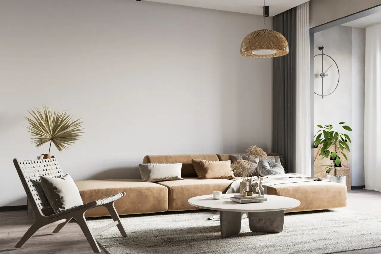 Salon w stylu wabi sabi: beżowa kanapa, pleciony fotel, suszone trawy i naturalne materiały tworzą przytulną atmosferę.