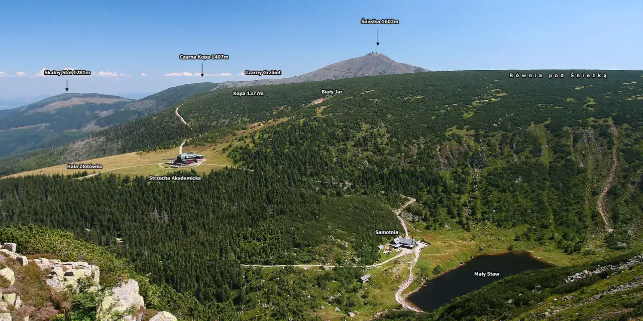 Widok na szczyty w Karkonoszach: Śnieżka, Czarna Kopa, Skalny Stół. W dole schroniska Strzecha Akademicka i Samotnia nad Małym Stawem.