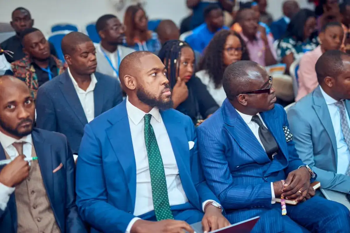 Men in suits listen intently, perhaps preparing questions for a leadership panel.