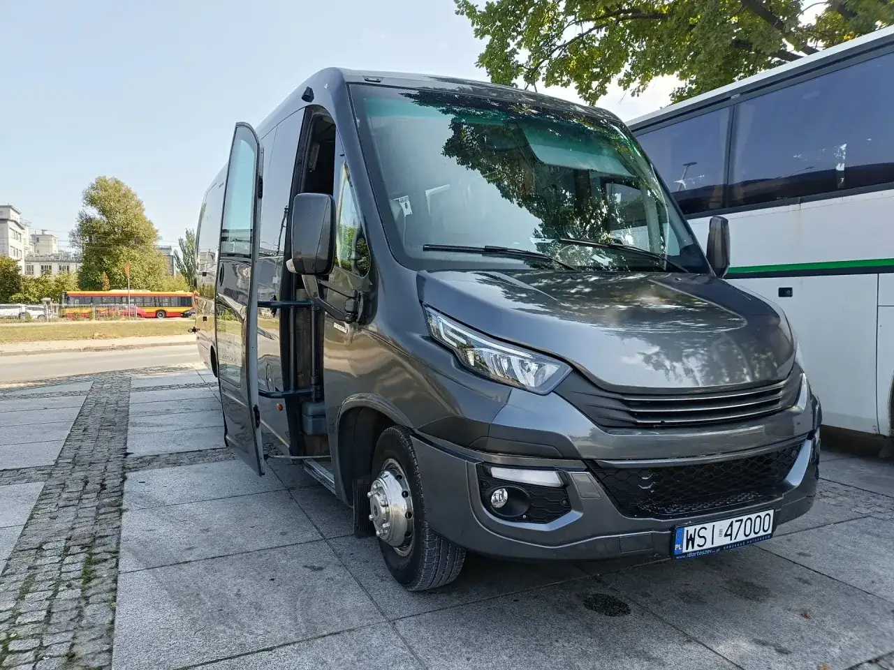 Szary bus z otwartymi drzwiami, gotowy do podróży. Sprawdź nasz wynajem busa z kierowcą cennik i zaplanuj wycieczkę!