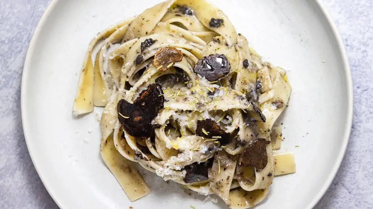Makaron tagliatelle z kawałkami czarnej trufli i parmezanem. Poczuj, jak smakują trufle w tym eleganckim daniu.