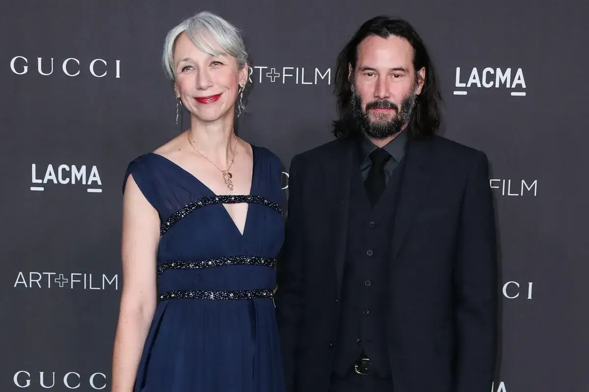 Keanu Reeves z żoną Alexandrą Grant na ściance. Ona w granatowej sukni, on w garniturze.