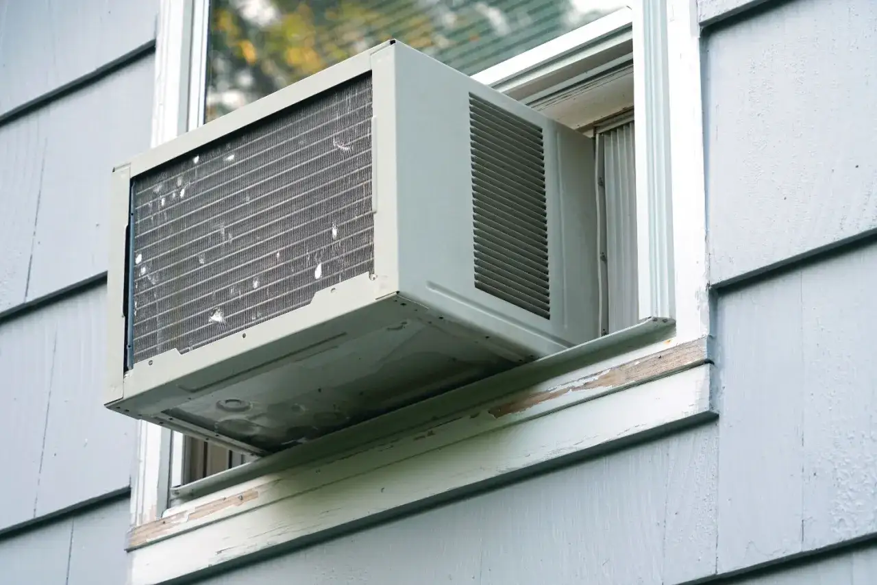 Climatiseur monobloc avis : une unité de climatisation installée dans une fenêtre, prête à rafraîchir la pièce.