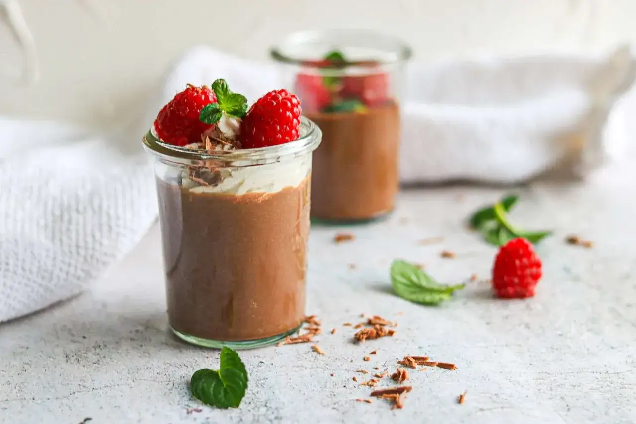 Schokocreme mit Puddingpulver, garniert mit Sahne, Himbeeren und Minze. Ein köstlicher Genuss!