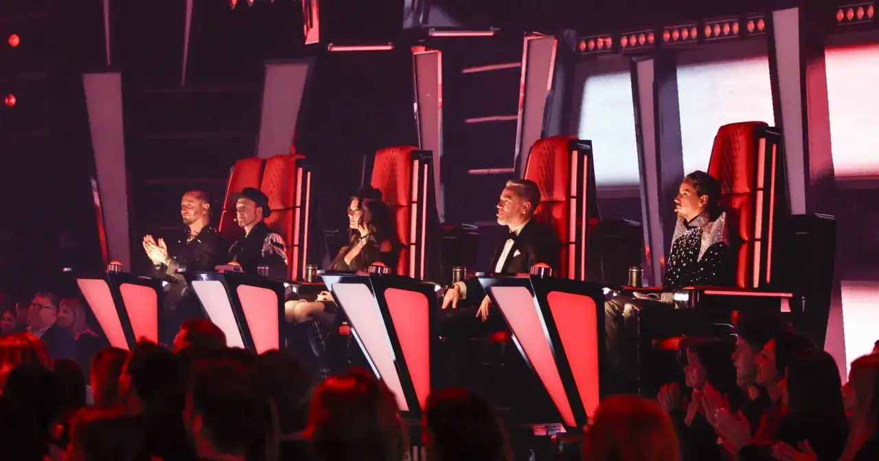 Jurorzy The Voice of Poland siedzą w czerwonych fotelach, oceniając występy.
