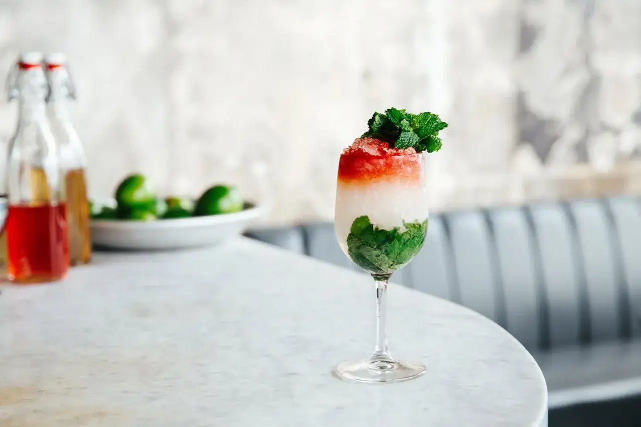 El Presidente cocktail med lager av mynta, is och r&ouml;d topping, garnerad med mynta.