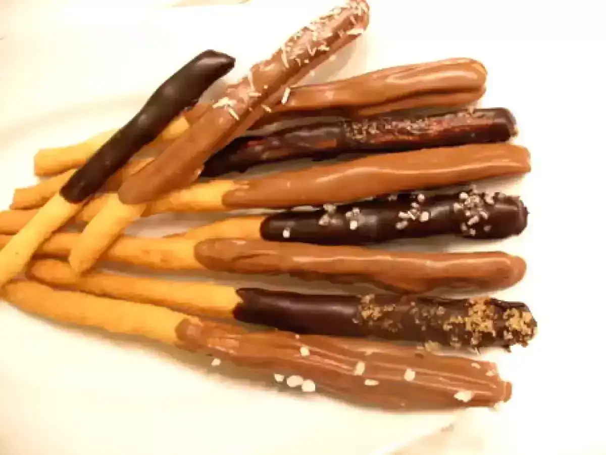 Des bâtonnets de biscuit trempés dans du chocolat noir et au lait, certains saupoudrés de sel ou de noix.