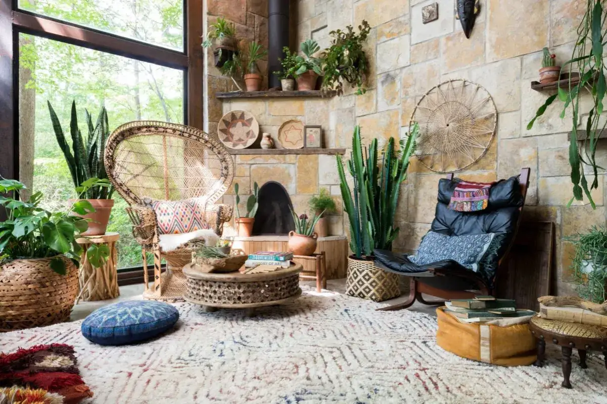 Un angolo accogliente per arredare casa: poltrona in vimini, cactus, tappeto etnico e piante rigogliose creano un'atmosfera boho-chic.