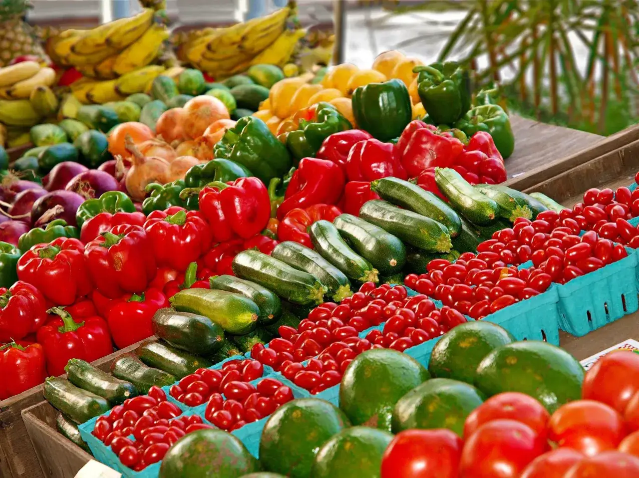 Un étal coloré d'un marché à Rome déborde de poivrons rouges et verts, de courgettes, de tomates cerises et de bananes.
