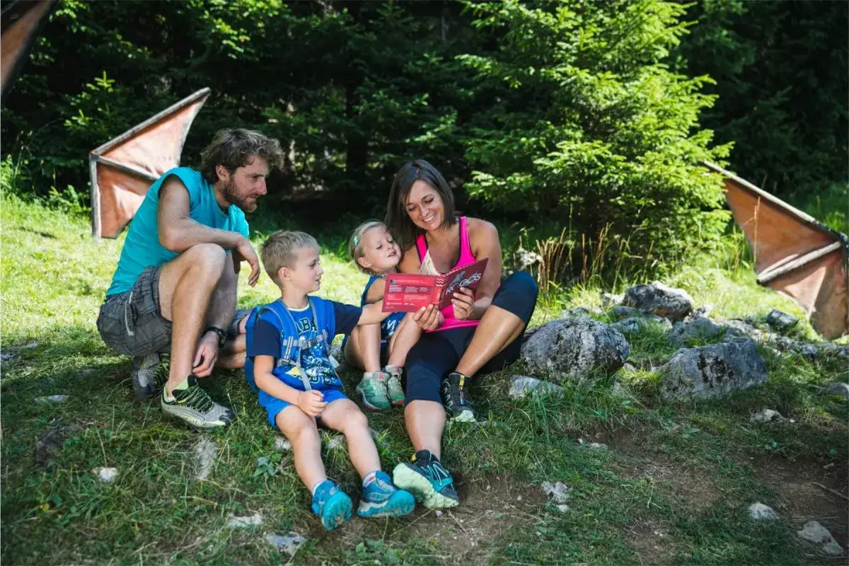 Famiglia in una montagna vicino Roma, con bambini che ascoltano una storia letta dalla madre.